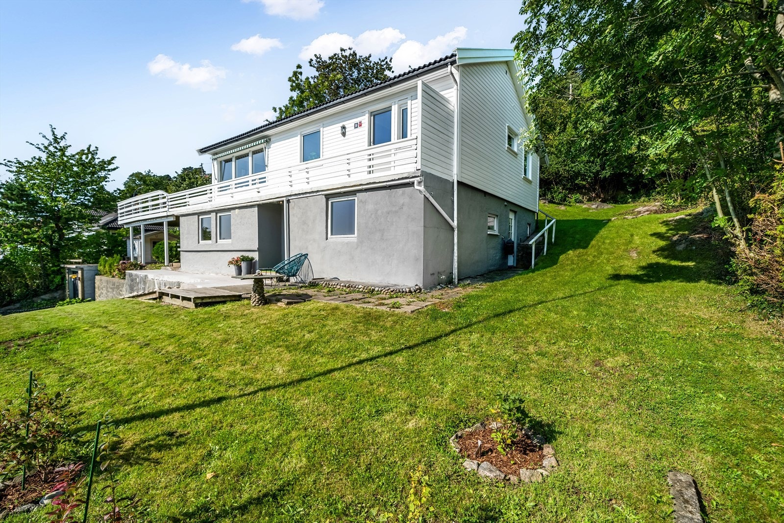 Hagen er opparbeidet med plen, frukttrær, busker og blomster Galleribilde