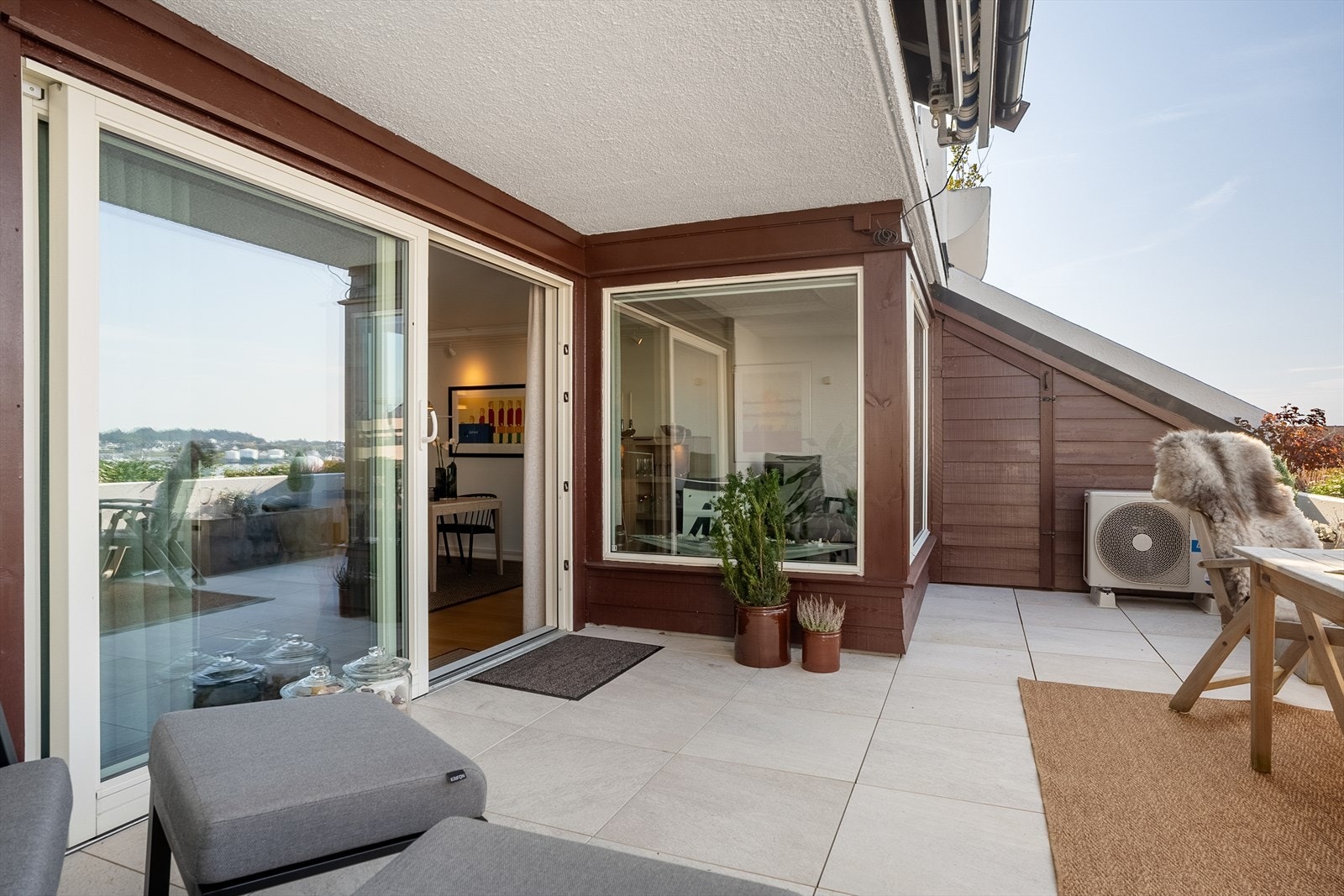 Stor og usjenert terrasse med bod (malt innvendig i 2024) og marmorfliser på gulv Galleribilde