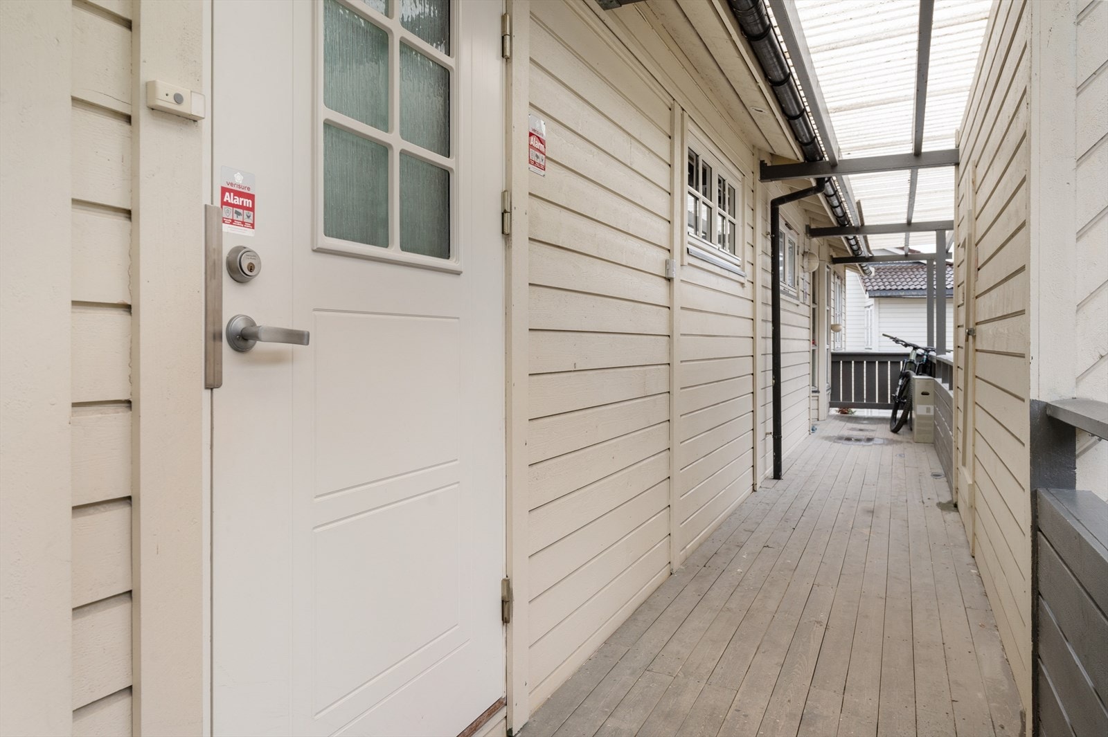 Takoverbygd inngangsparti med tilgang til en utvendig sportsbod like utenfor inngangsdøra. Galleribilde