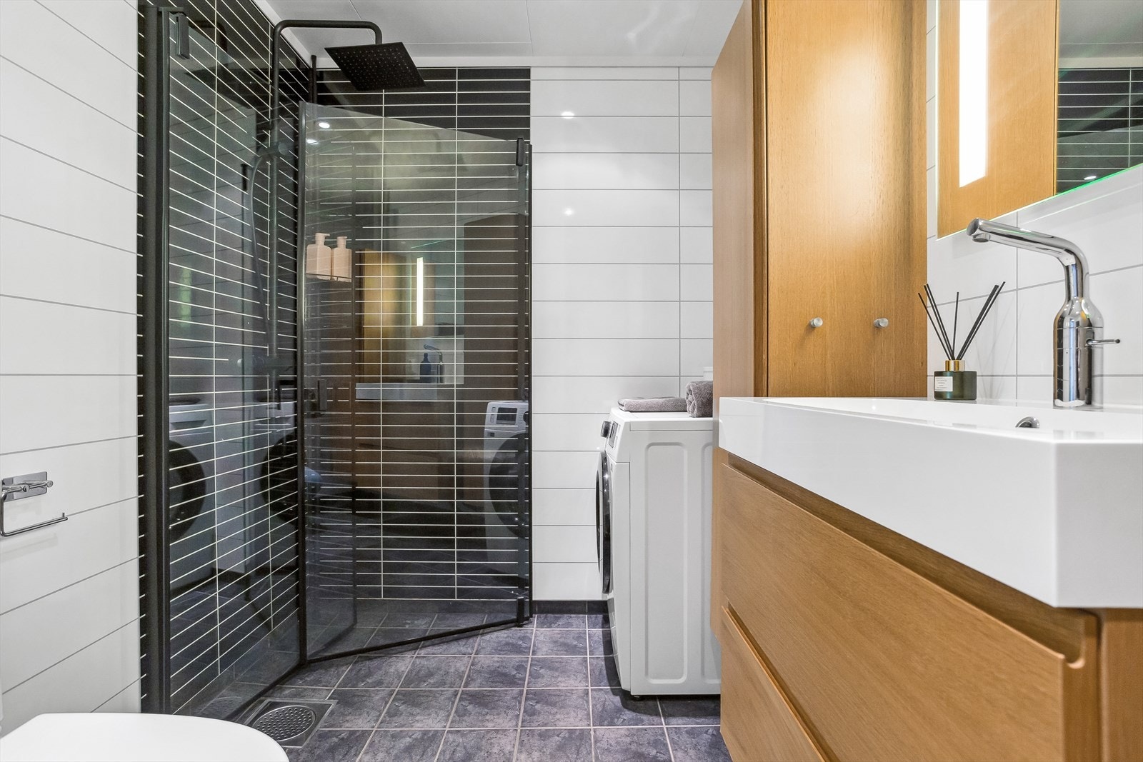 - Badet inneholder dusjhjørne med glassdører, toalett, servant med underskap, speil på vegg, 2 stk høyskap montert på vegg og opplegg for vaskemaskin Galleribilde