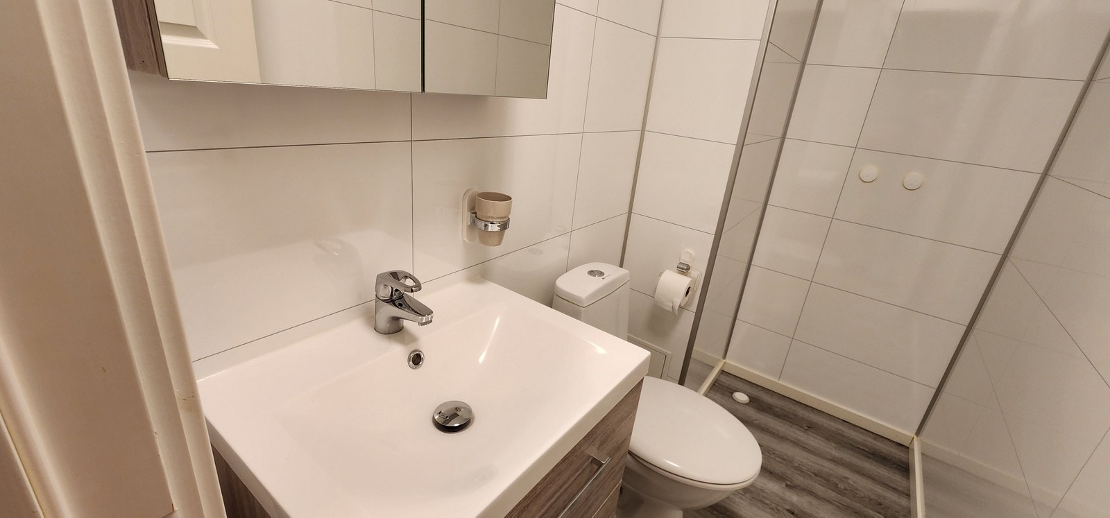 Bad nummer 2. Badet inneholder dusj, toalett, speil og vask med underskap. Galleribilde
