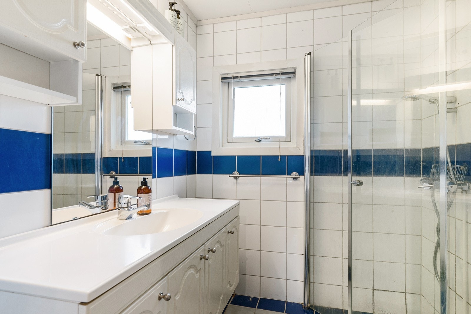 Badet er innredet med servantinnredning, toalett & dusjhjørne. Galleribilde