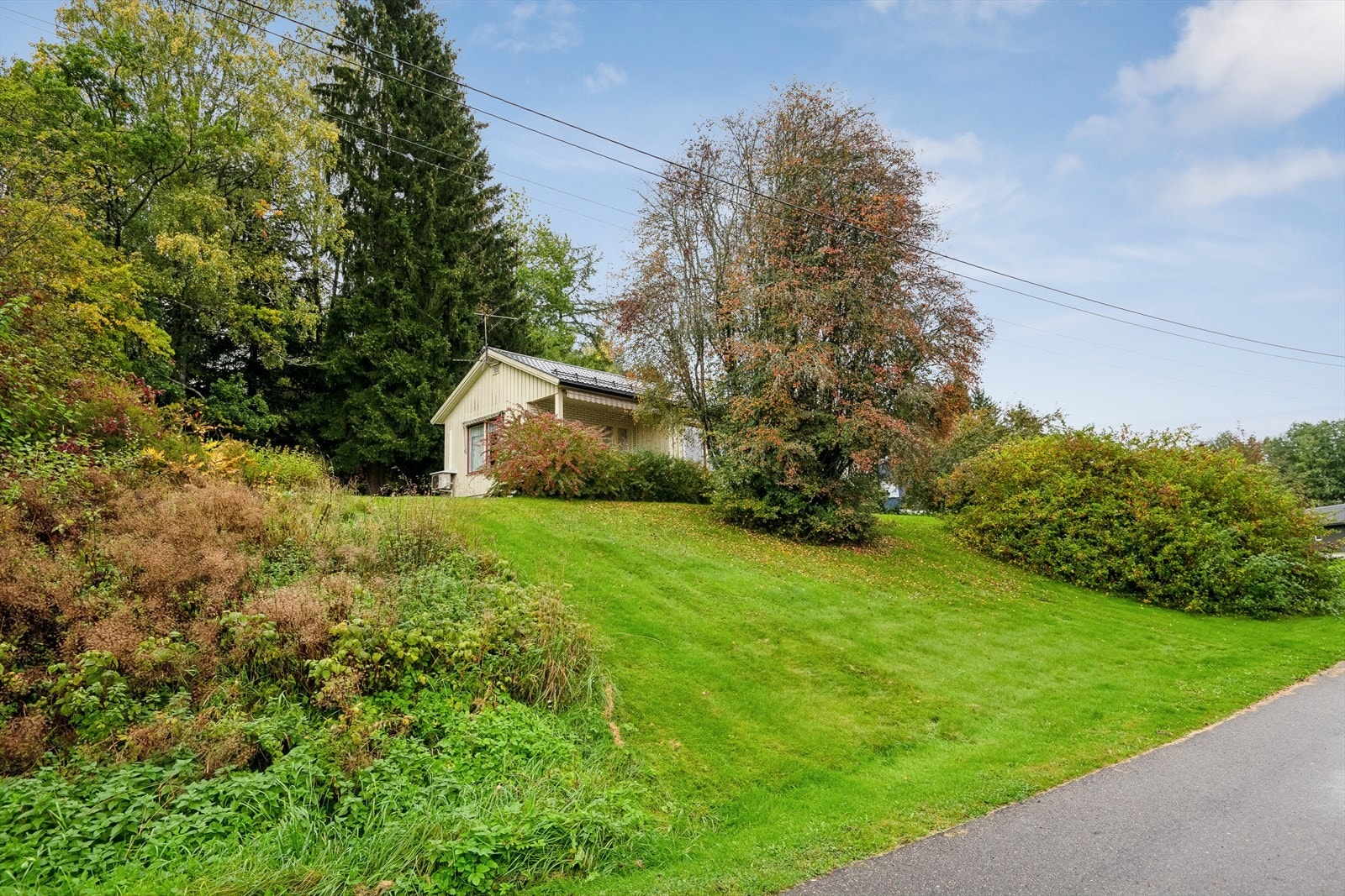 Dette er en skrånende hjørnetomt hvor en del av tomten er naturtomt. Galleribilde