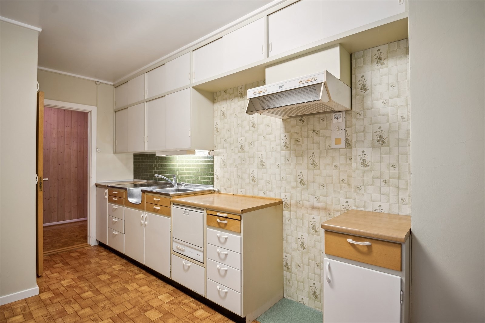 Kjøkkenet har en eldre innredning med plassbygd skap, malt innredning og benkeplate i laminat. Galleribilde