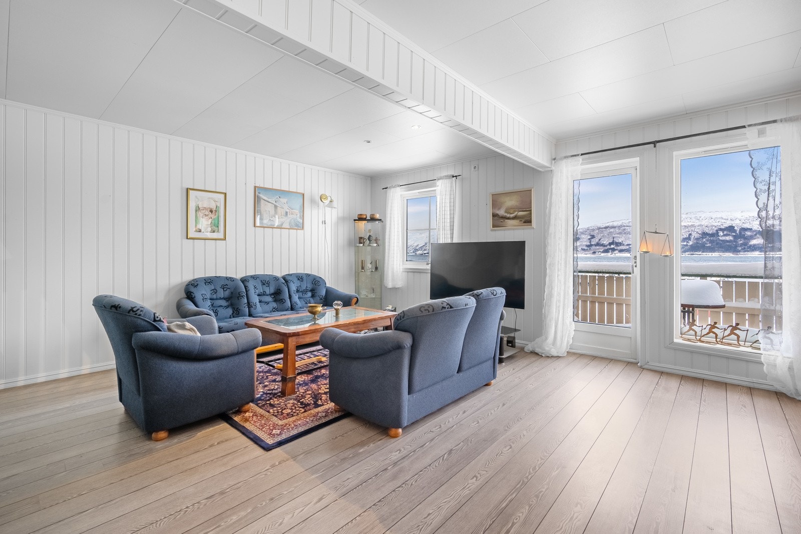 Stuen er av god størrelse og rommer plass til sofagruppe og spisebord med tilhørende møblement Galleribilde