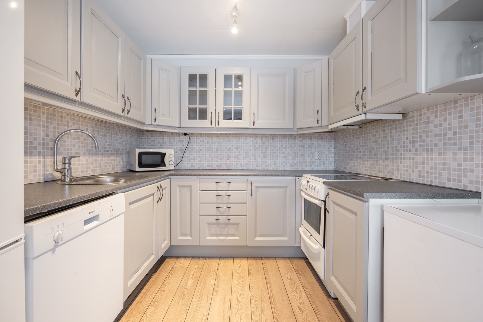 Kjøkkenet har godt med skap og benkeplass Galleribilde