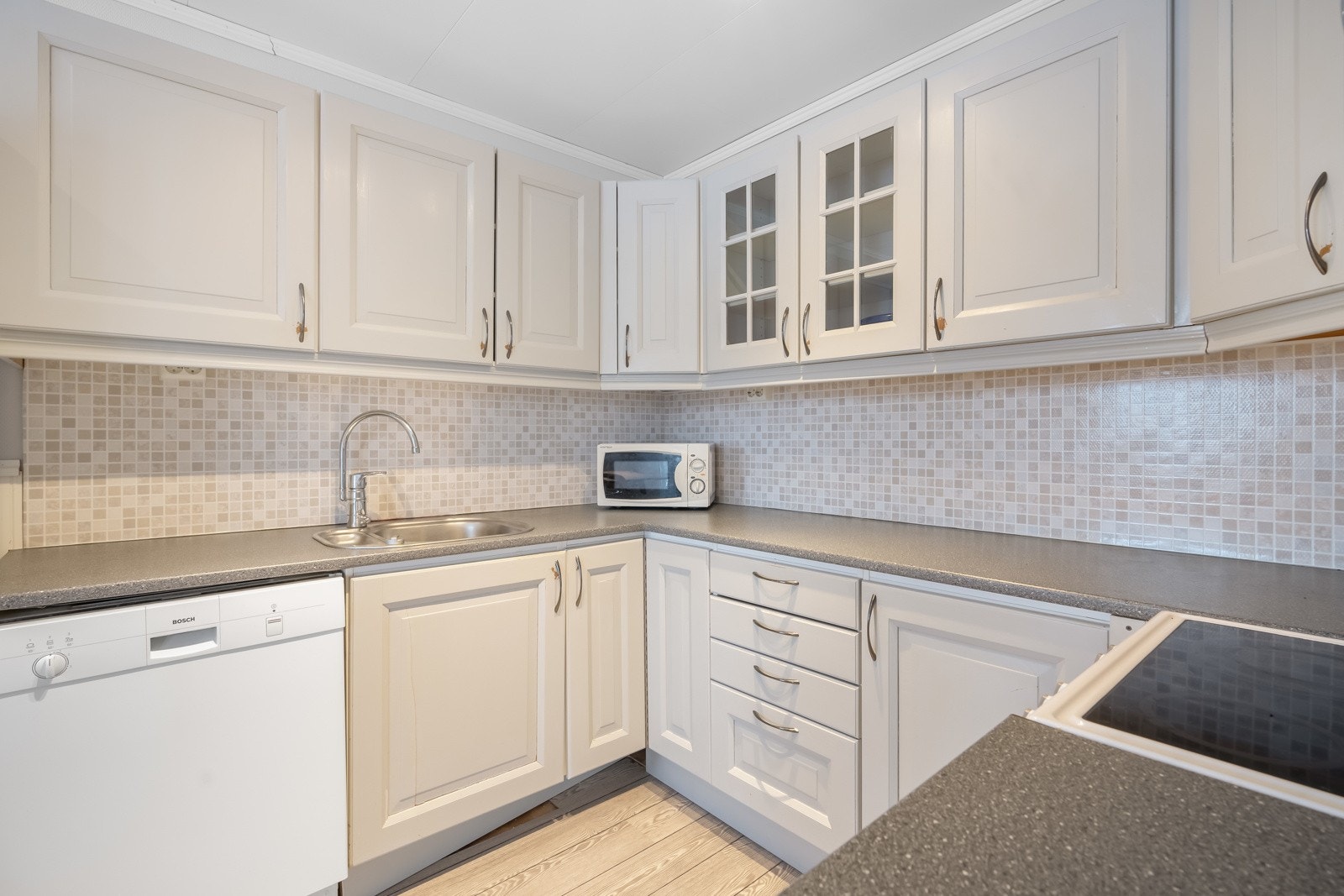 Kjøkkeninnredning med laminerte fronter, laminert benkeplate og frittstående hvitevarer Galleribilde