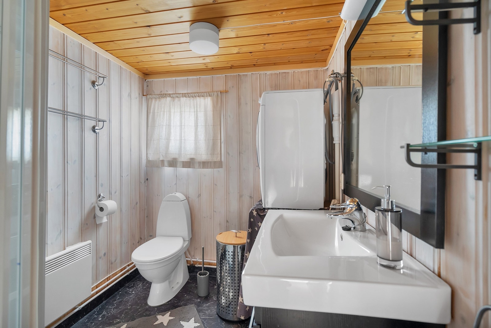 Badet har servant med skuffer under, dusjkabinett, wc, og opplegg for vaskemaskin. Galleribilde