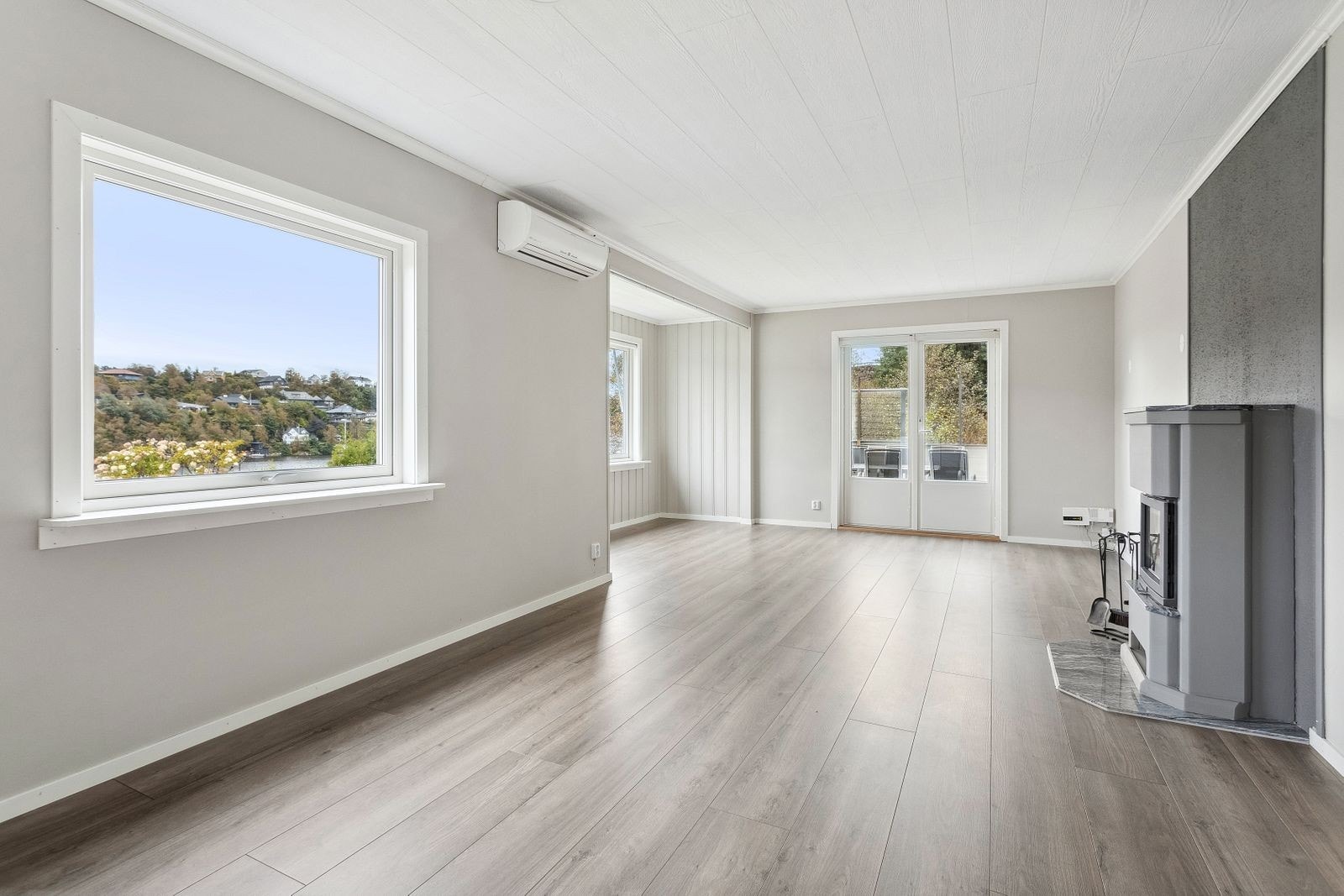 Stor og lys stue med vedovn. Utgang til terrasse. Galleribilde