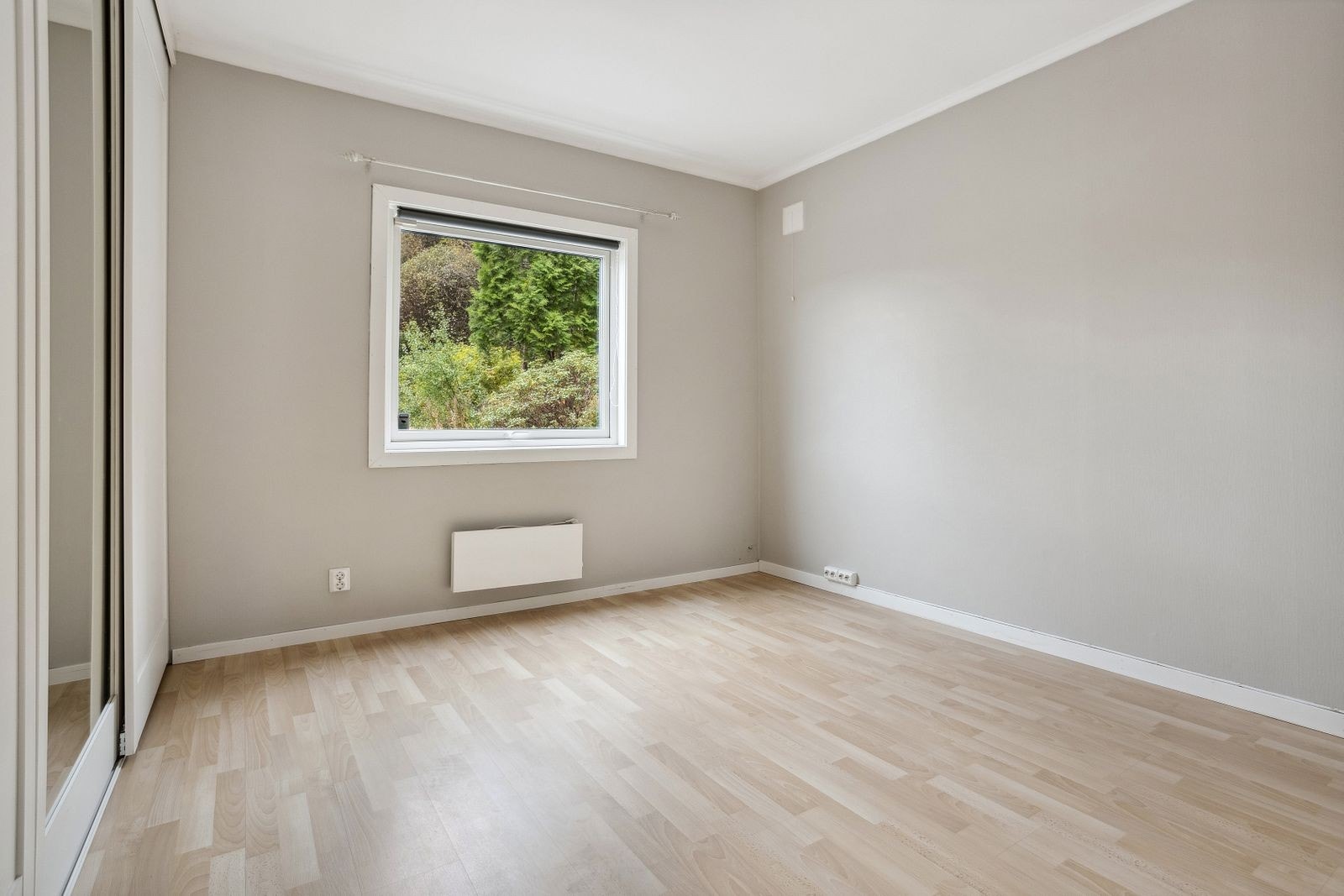 Stort og lyst soverom som inneholder skyvedørsgarderobe. God plass til møblering. Galleribilde