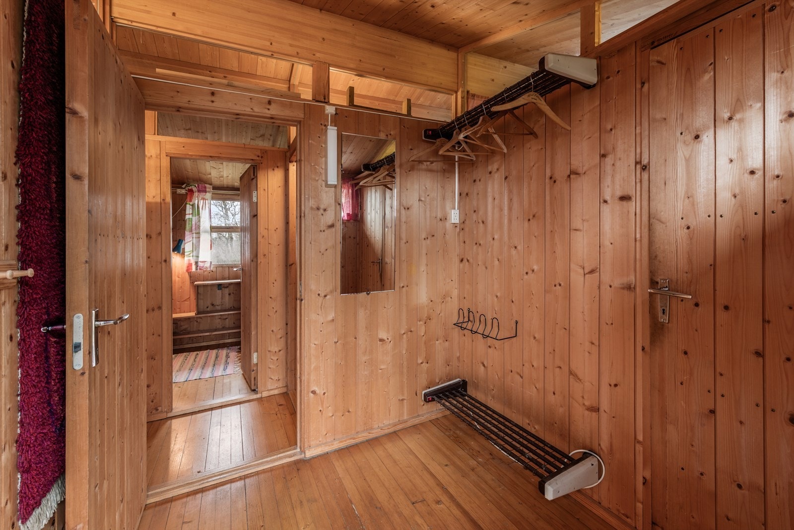 Entré er innredet med garderobeoppheng og skohylle med varmer Galleribilde