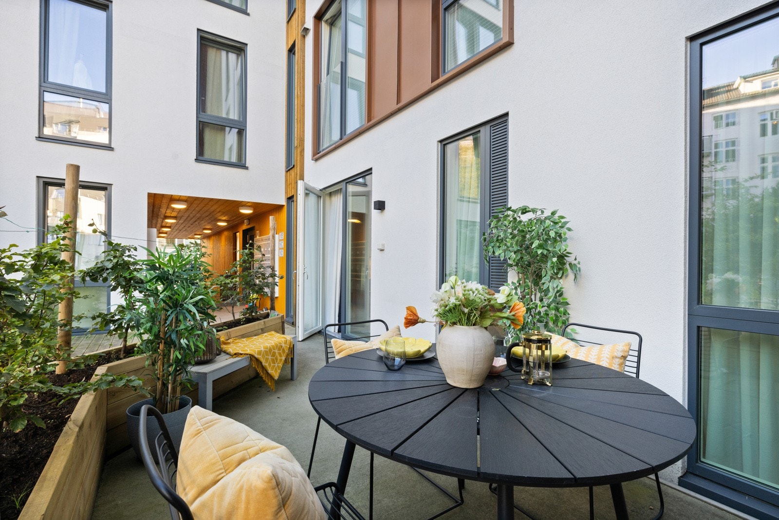 Østvendt, herlig uteplass på ca. 11 kvm. Her er det fin plass til en sittegruppe, og uteplassen rammes inn med plassbygde blomsterkasser i tre og grønne prudbusker på toppen. Galleribilde
