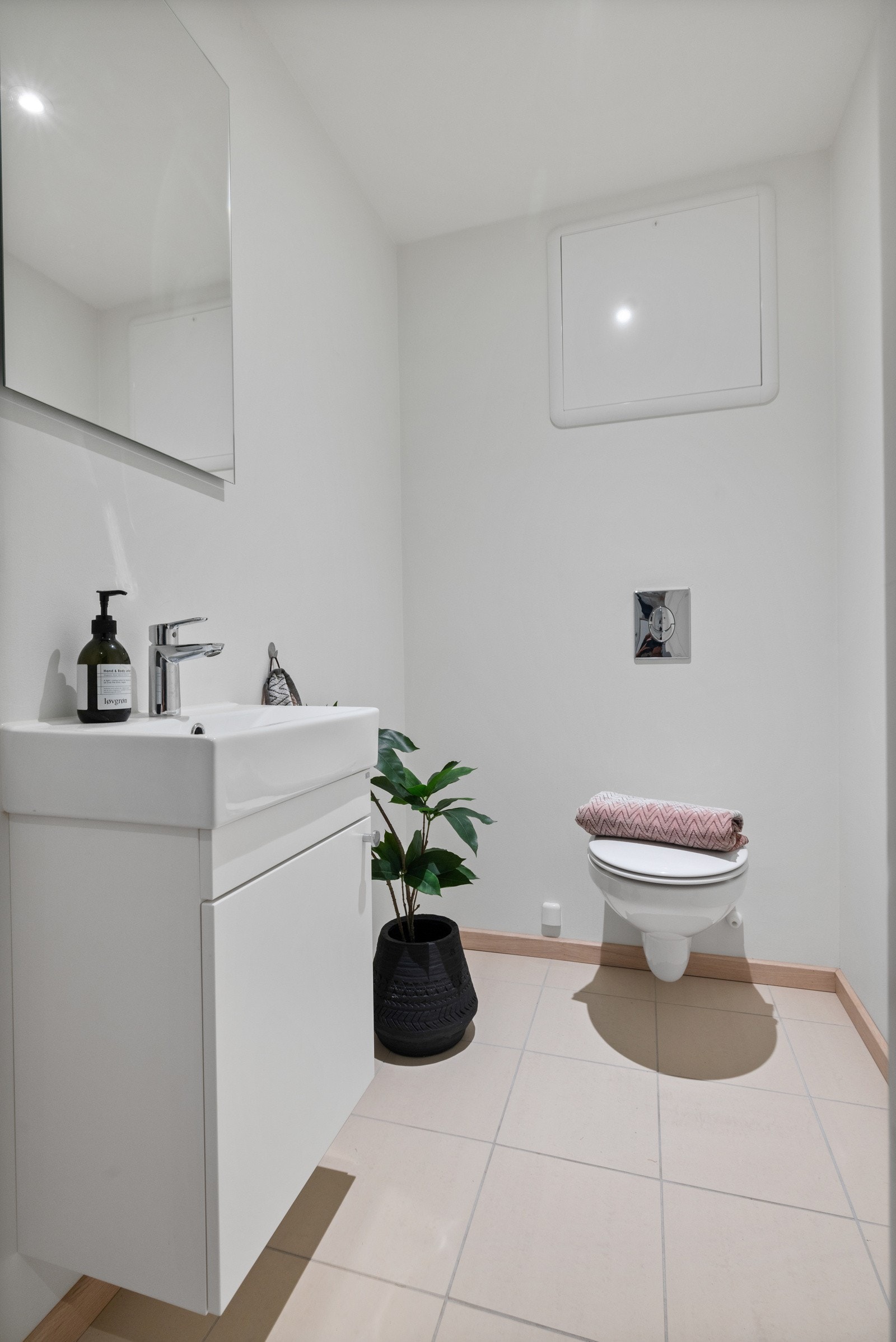 I hendig tilknytning til entreen er det et pent, separat wc-rom med hvitmalte vegger og lyse fliser på gulv med gulvvarme. Galleribilde