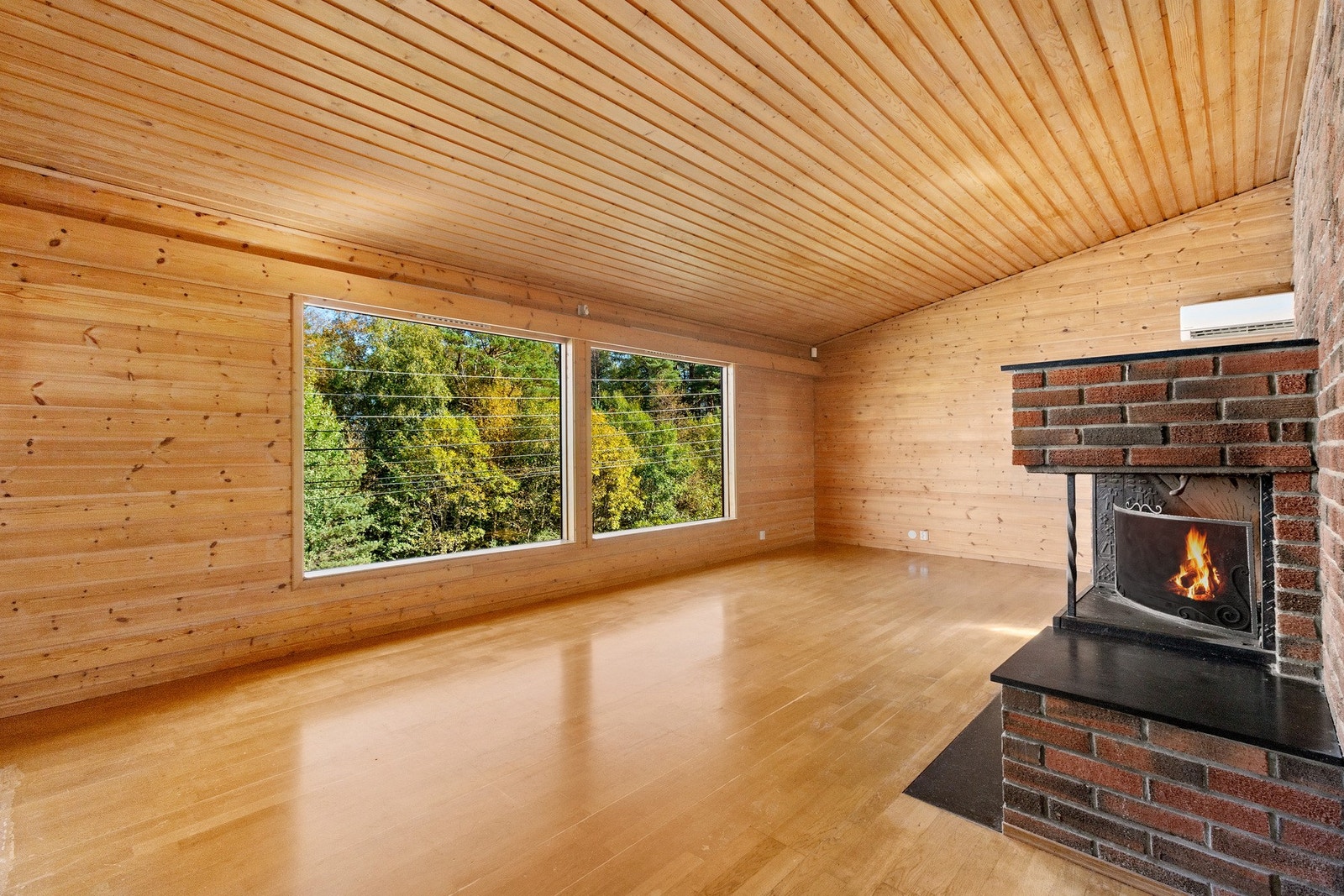 Stue med store vinduer og full takhøyde til møne Galleribilde