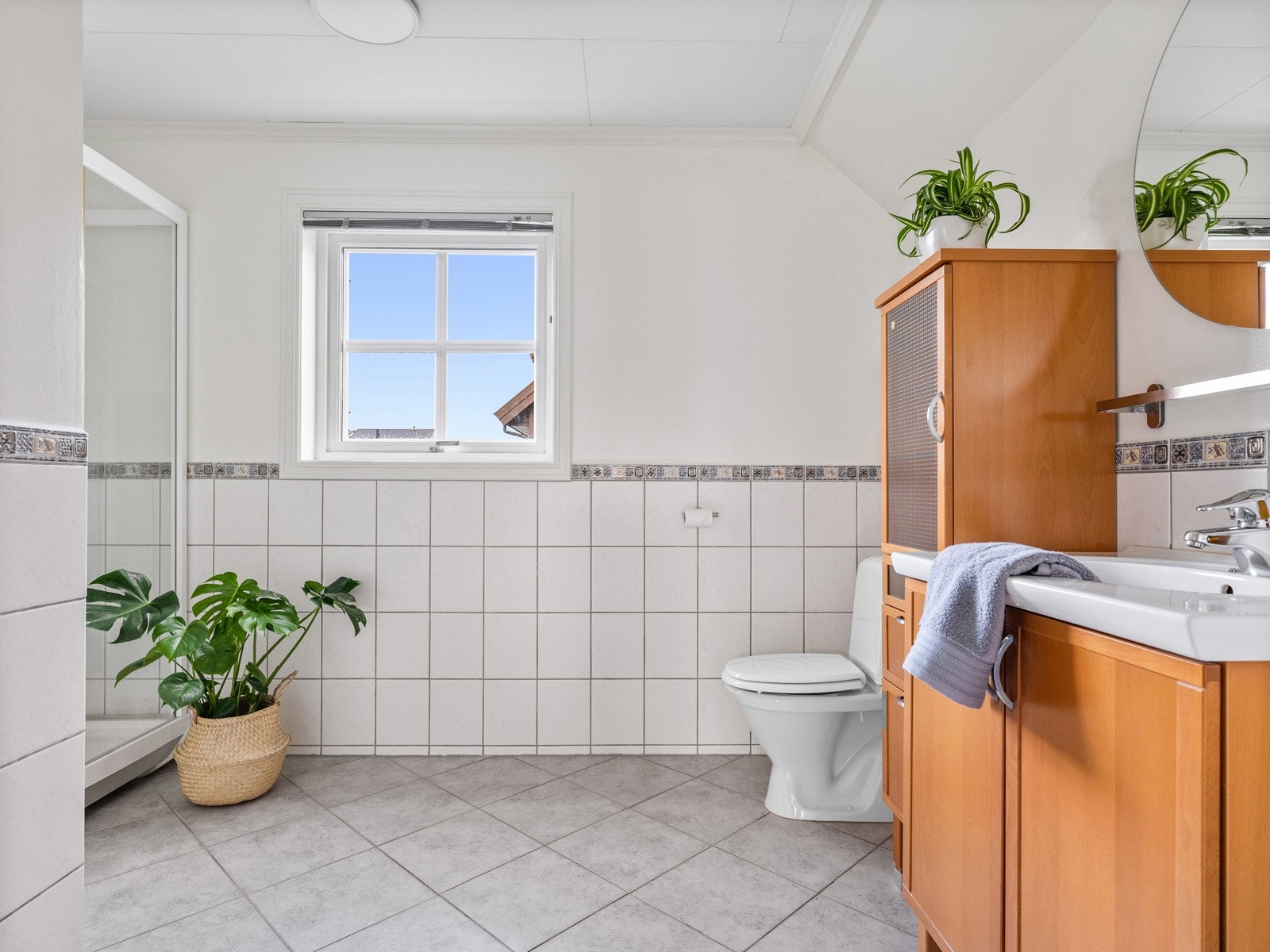 Baderom utstyrt med dusjkabinett, toalett og servant i seksjon. Galleribilde