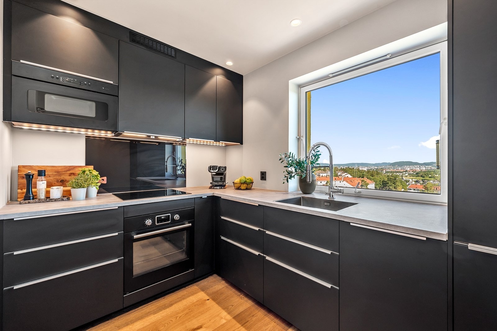 - Det er nedfelt vask og en platetopp i benkeplaten. Ett-greps blandebatteri og downlights under overskap - Galleribilde