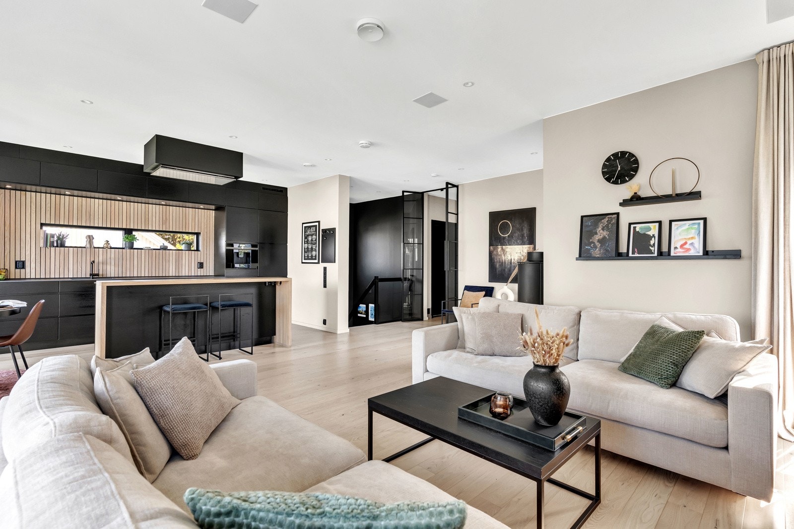 Med sine generøse dimensjoner, integrert i en åpen løsning mot stuen, sørger rommet for en luftig og inviterende atmosfære Galleribilde