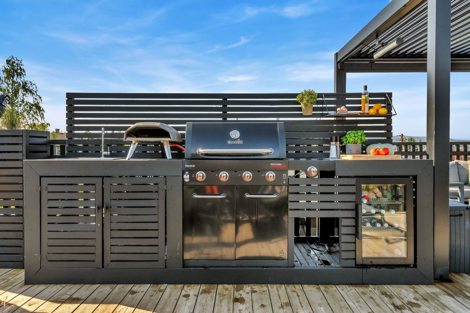 Utendørs kjøkken med kjøleskap, god benke- og skapplass. Samt. Vask med vanntilgang. Galleribilde