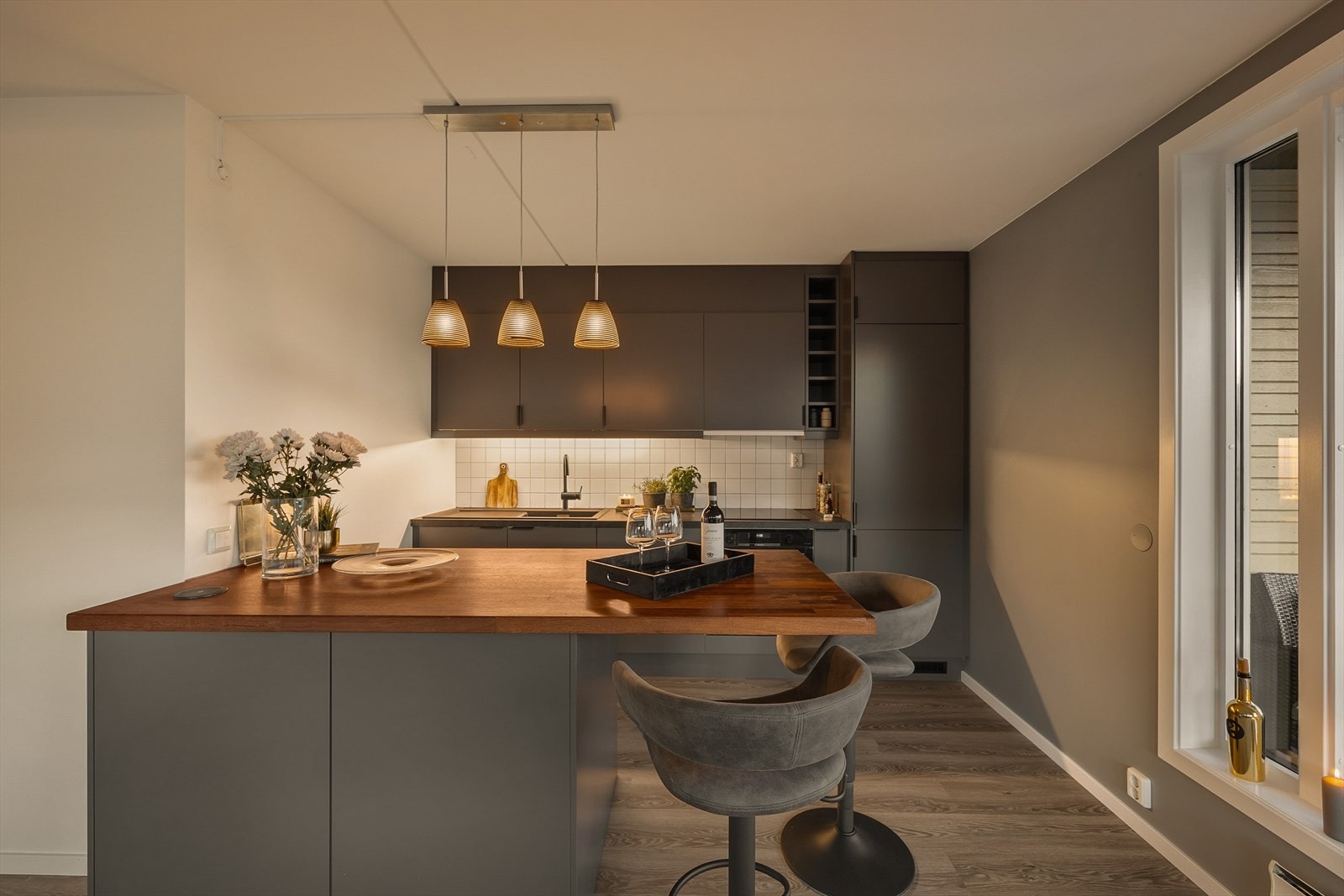 Kjøkkenøyen skaper et naturlig skille mellom kjøkkenet og stuen Galleribilde