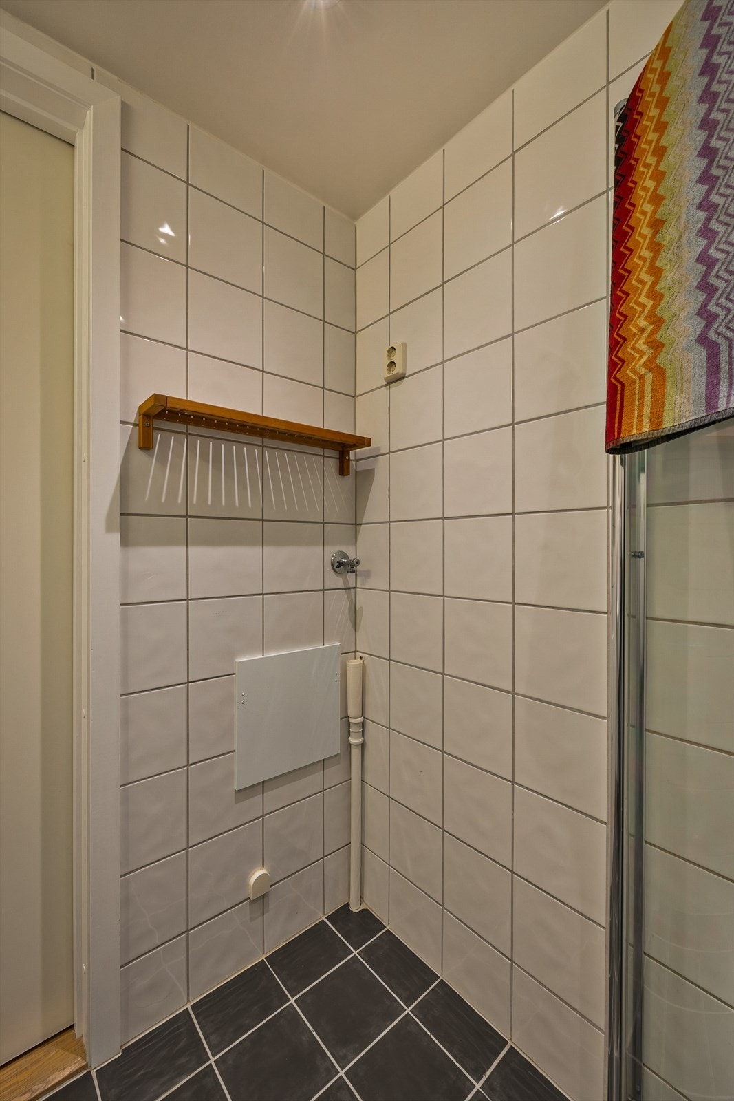 Innredning består av servant med 1-greps blandebatteri. Dusjhjørne med glassdører, opplegg for vaskemaskin og vegghengt toalett. Galleribilde