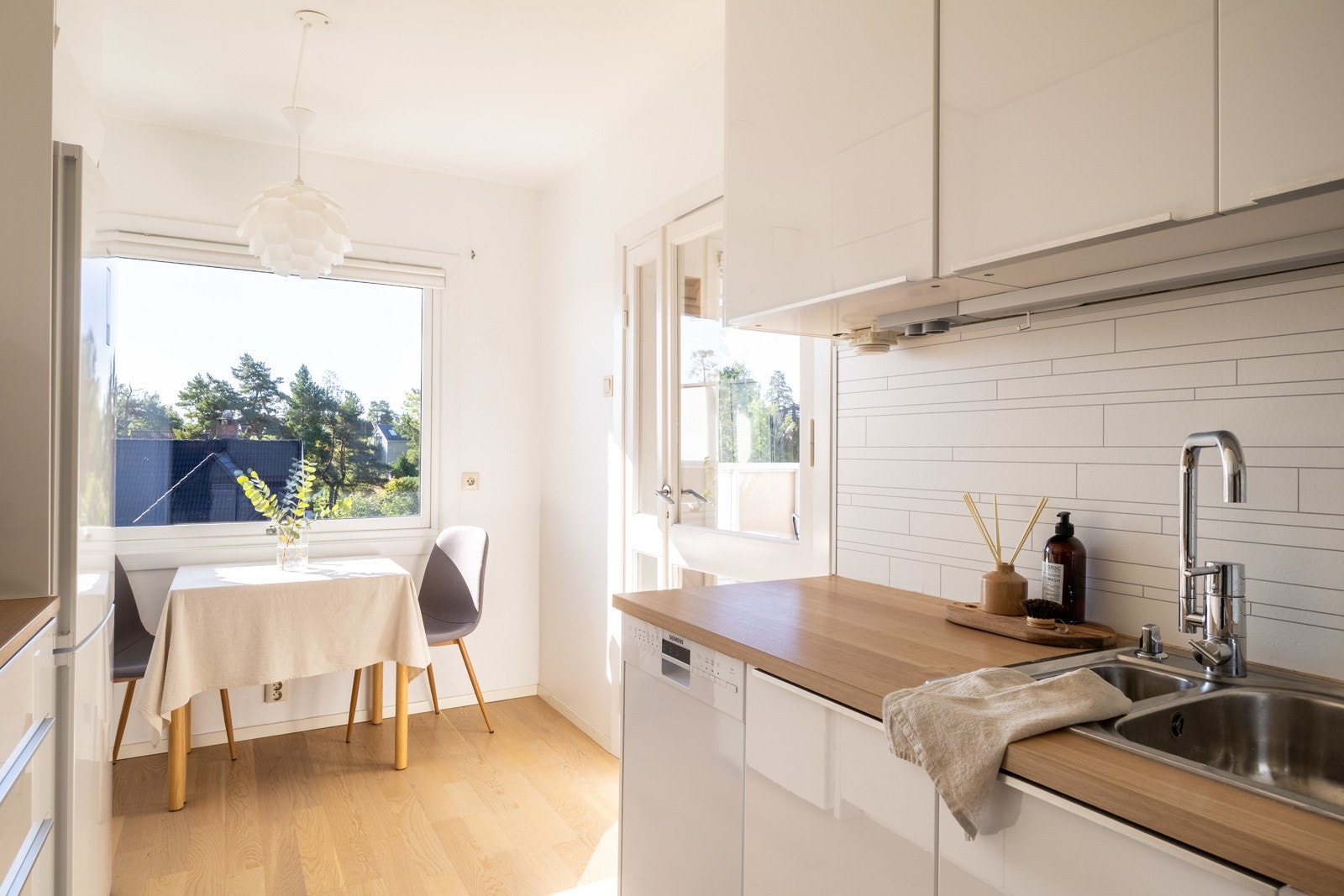 Leiligheten har et separat kjøkken med hvite fronter og benkeplate av laminat. Galleribilde