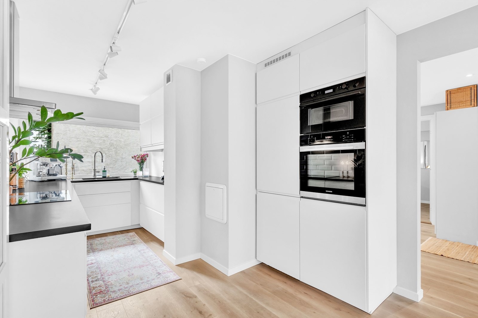 Videre er innredningen utstyrt med integrerte hvitevarer, inkludert en komfyr, steketopp, oppvaskmaskin og kjøle-/fryseskap, som alle bidrar til en effektiv og behagelig matlagingsopplevelse. Galleribilde