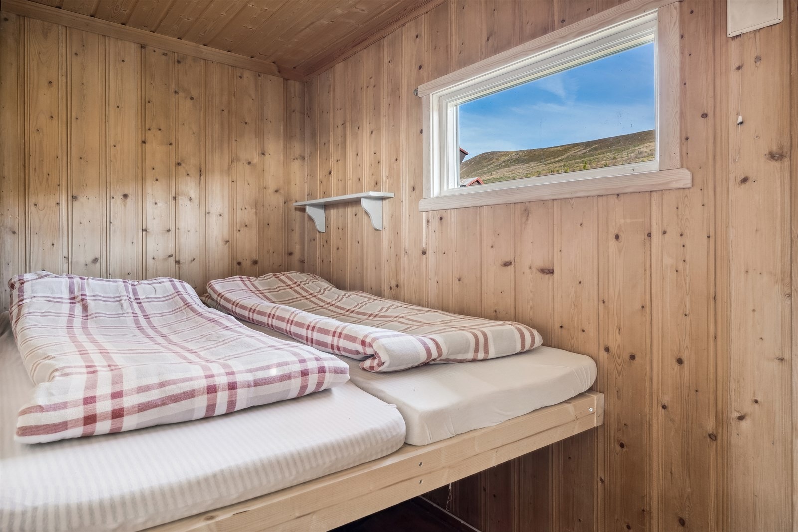 De disponible rommene er ikke godkjent som rom for varig opphold grunnet for lite vindu for godkjent rømningsvei. Dette innredet med plassbygd dobbeltseng. Galleribilde