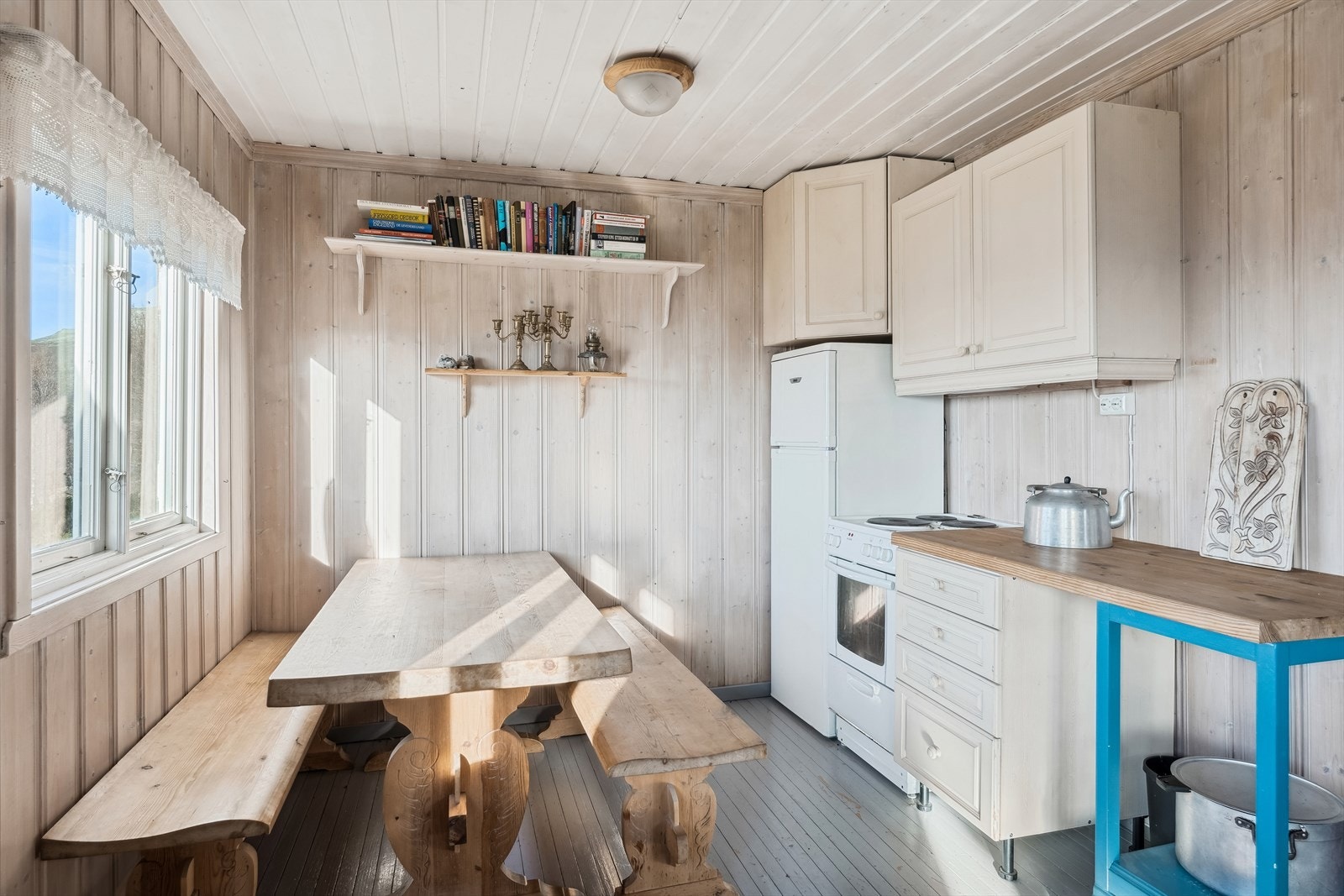 Kjøkkenet er lys og hyggelig med kjøkkeninnredning med profilerte fronter. Enkel innredningen uten vaskekum, men med hvitevarer som kjøl-/fryseskap og komfyr. Oppbevaringsplass i over- og underskap. Galleribilde