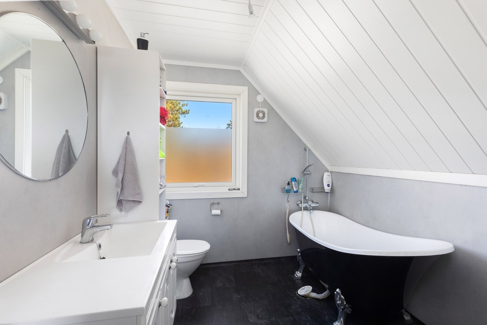 Bad på loftet har nyere overflater. Her er elektriske varmekabler i gulv, nedfelt servant, toalett og badekar. Galleribilde