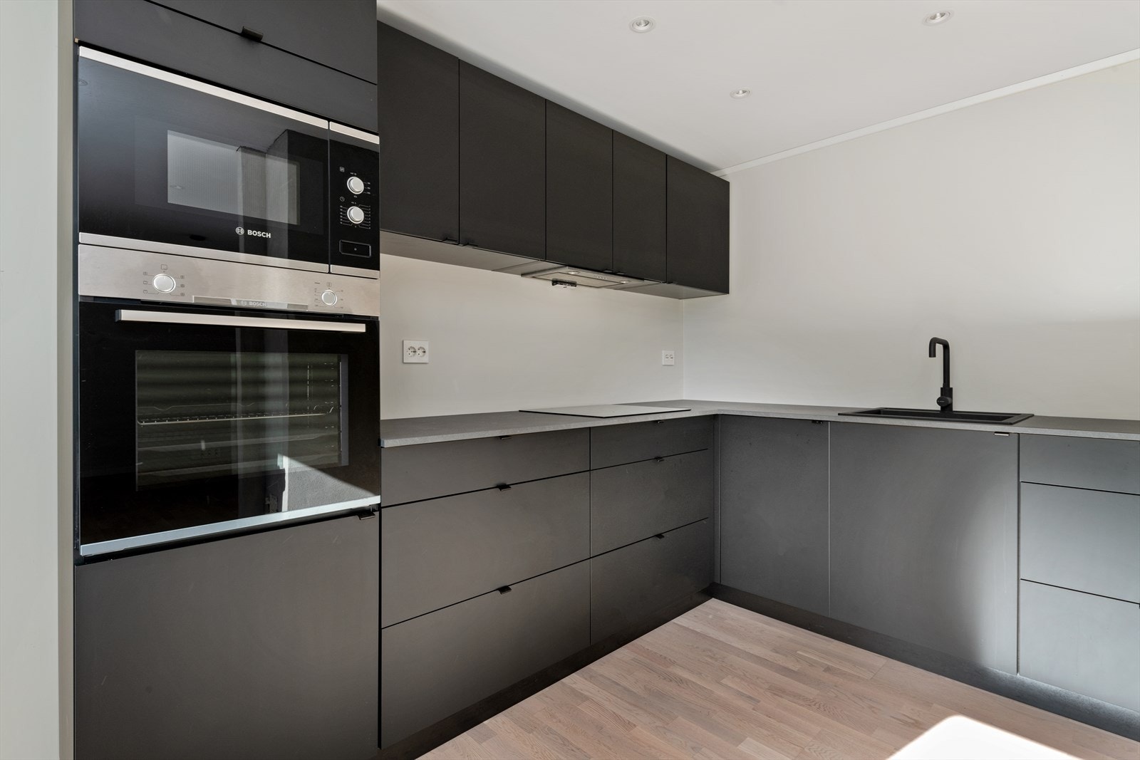 Kjøkkenet ligger i åpning til stuen, som gjør rommet mer sosialt ved besøk.
Innredningen er fra 2019 og er med sorte fronter og laminat benkeplate Galleribilde