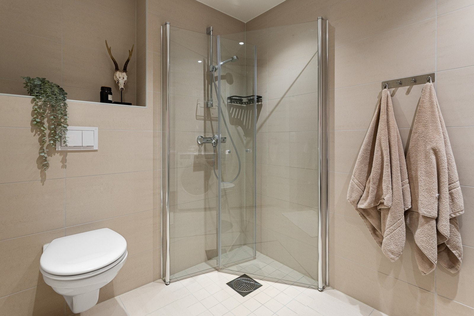 Baderomsinnredningen består av vegghengt servantskap, speil over servant med overlys og stikkontakter på vegg. Galleribilde