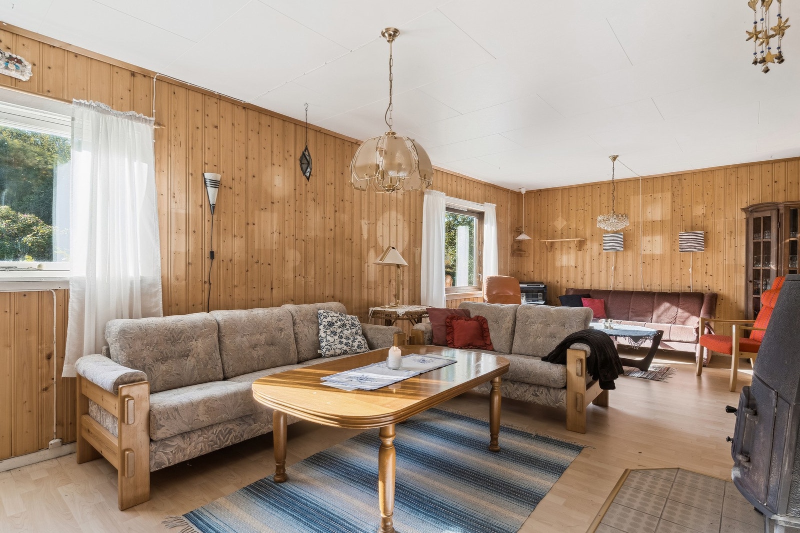 Romslig stue med plass for flere sittegrupper. Galleribilde