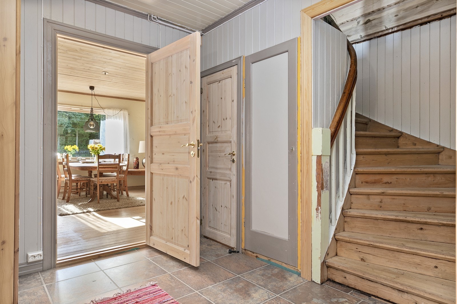 Hallen har laminatfliser på gulv og malt panel på vegger og himling. Galleribilde