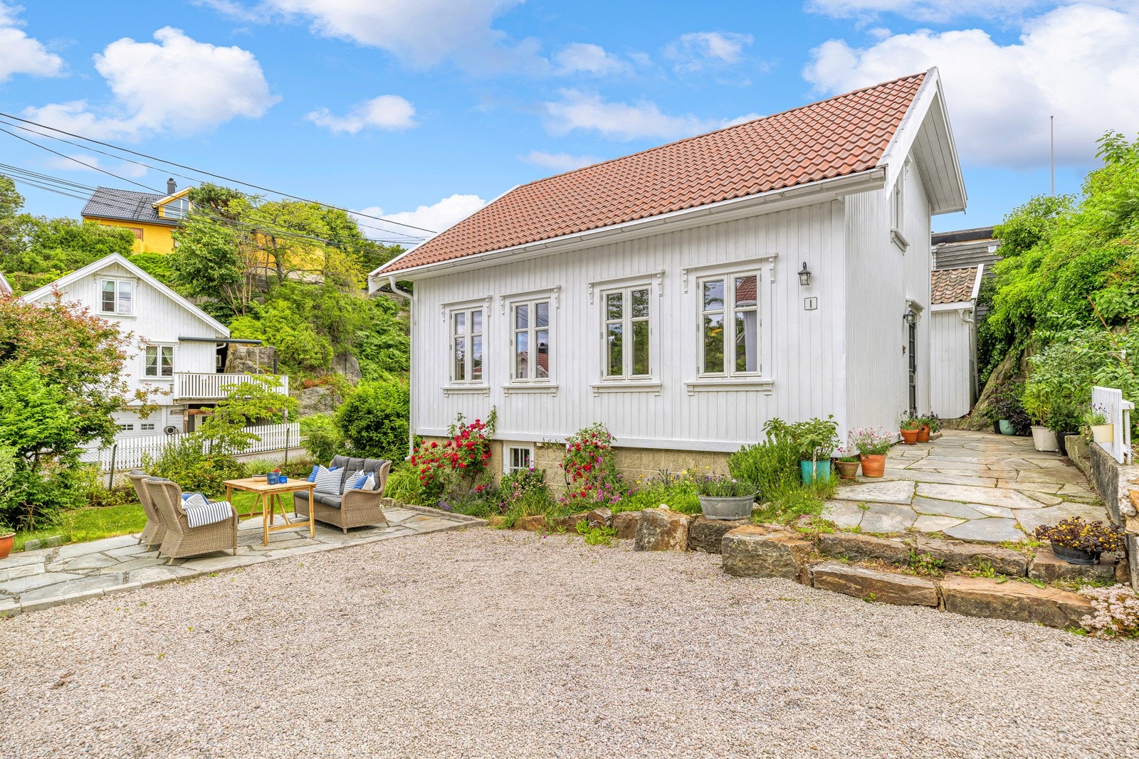 Bilen parkeres på en gruslagt gårdsplass foran huset. Galleribilde