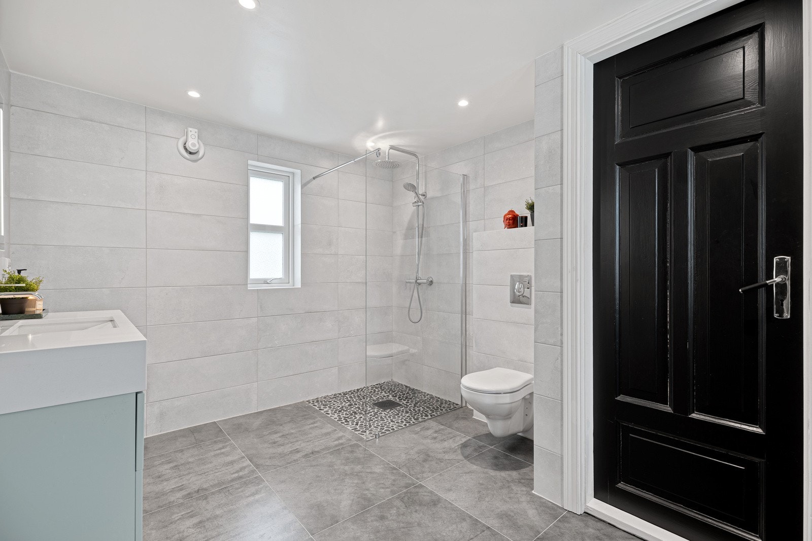 Dagene får en god start på et stort og flislagt bad med regnfallsdusj og varmekabler. Galleribilde