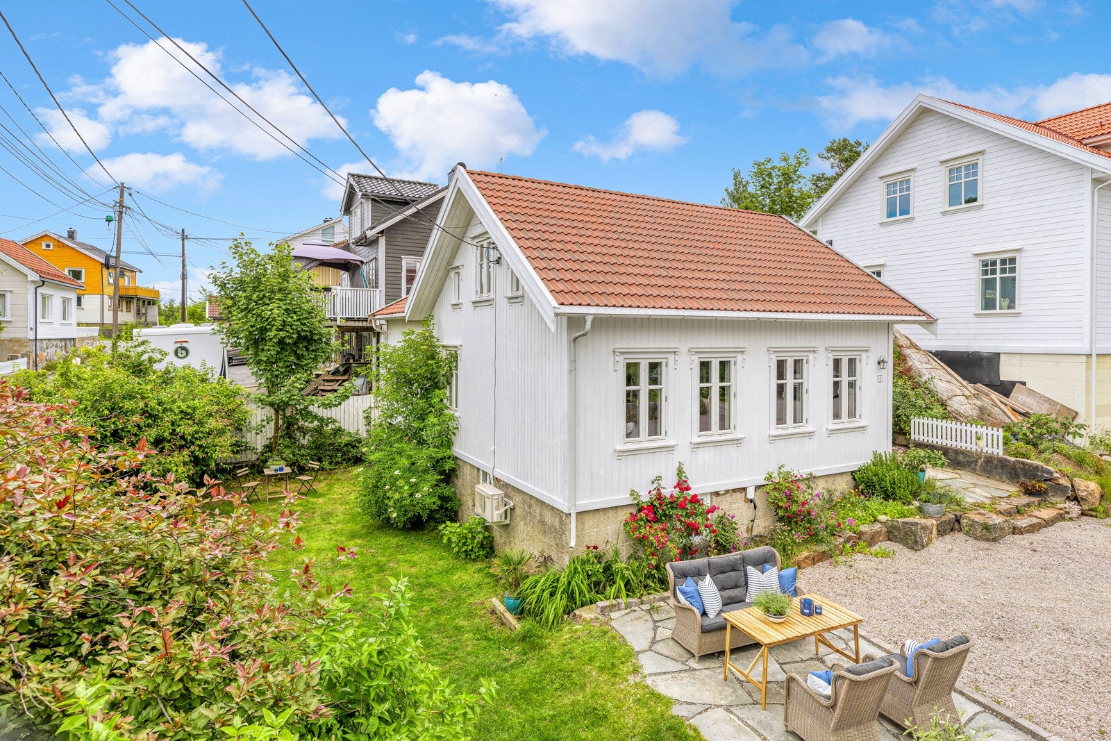 Villaen har en idyllisk hage, pent opparbeidet med gressplen, blomster og prydbuser. Galleribilde