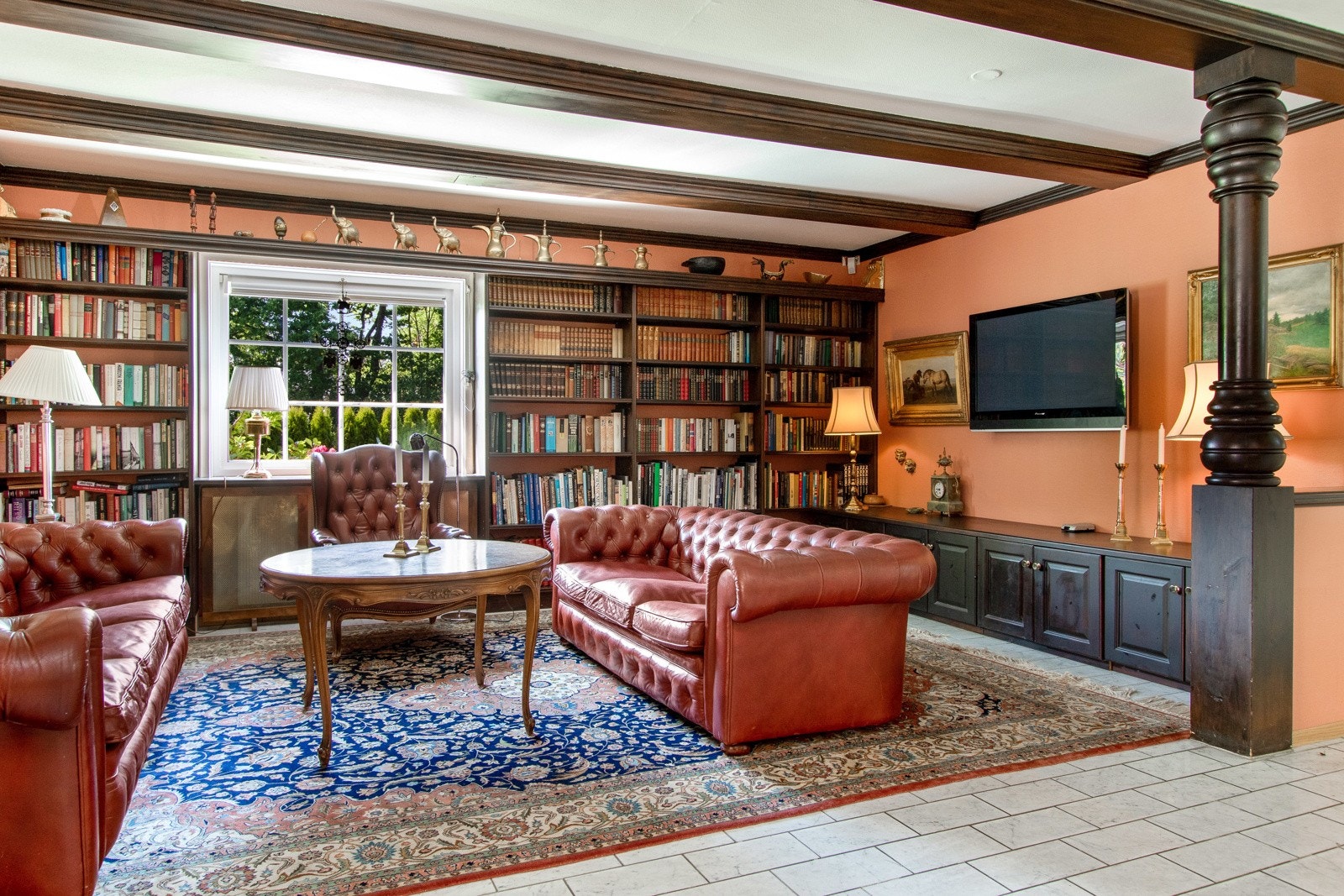 Biblioteket har særpreg med brunbeisede takbjelker og plassbygde bokhyller langs en hel vegg. Galleribilde