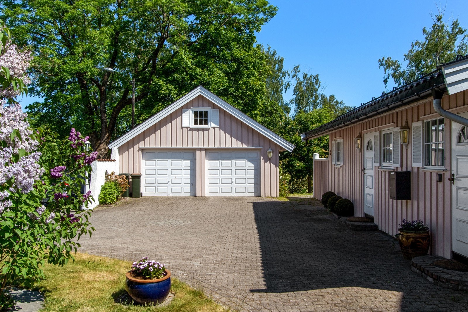 Det er parkering i dobbel garasje. Gårdsplassen har belegningsstein og god plass til flere biler. Galleribilde