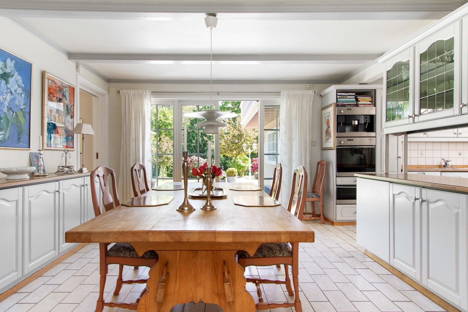 Kjøkkenet har gulv med marmorfliser, lysmalte vegger og hvit, slett himling med bjelker. Galleribilde