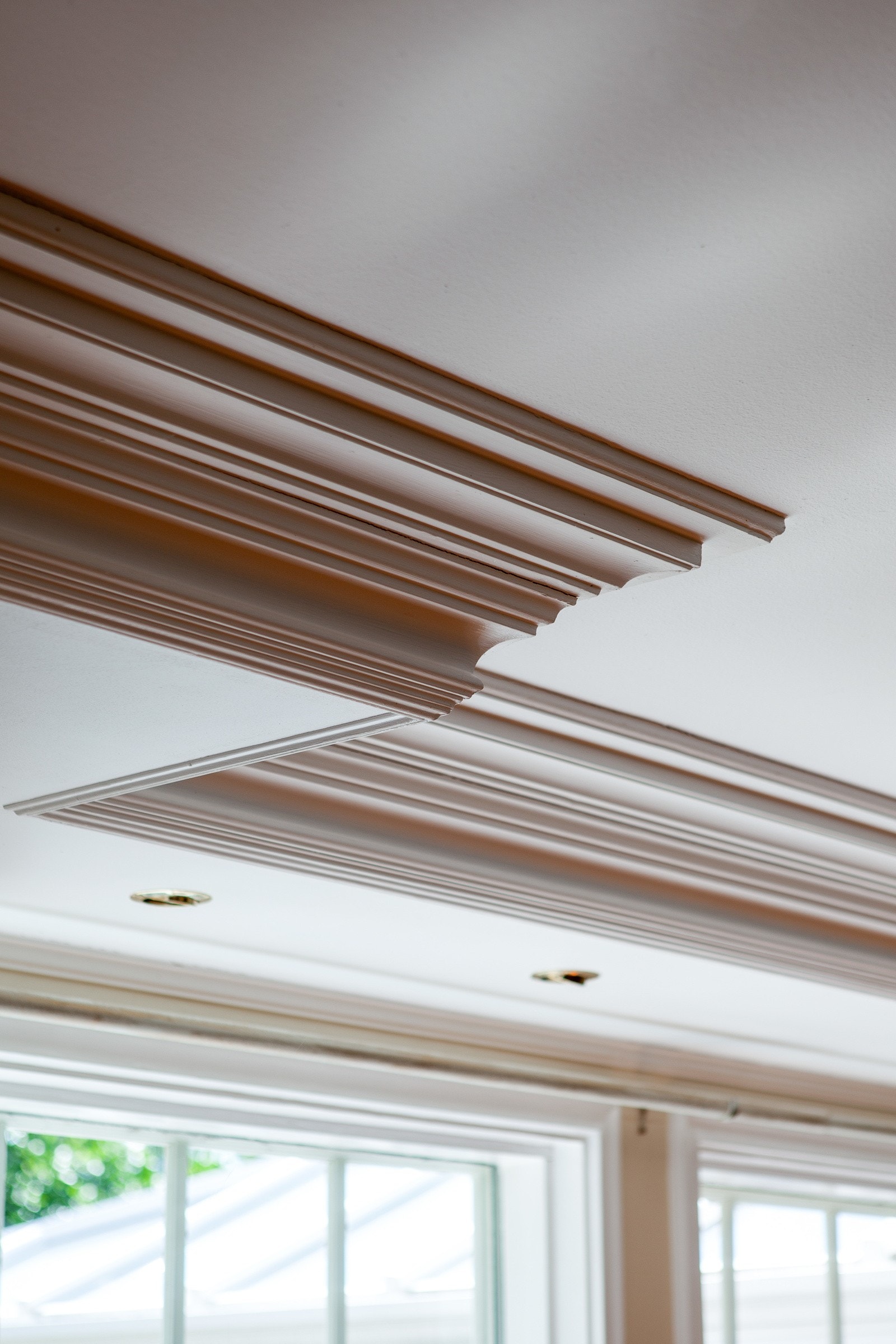 Himlingen er hvitmalt og slett, men langs veggene er det nedforet himling med downlights og brede, profilerte lister. Galleribilde