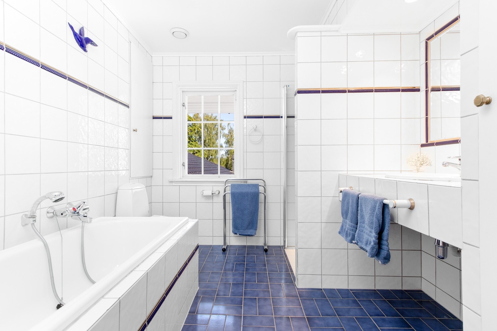 Det andre badet har badekar, dusjnisje, wc, flislagt benk med nedfelt servant, et innebygd skap og et innfliset speil. Galleribilde