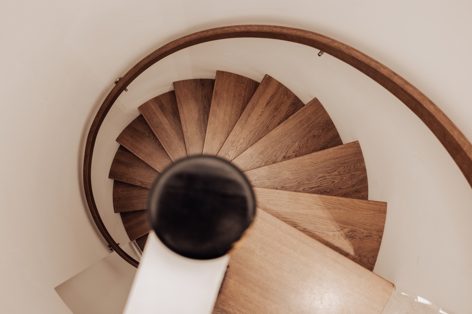 Spiraltrapp i metallkonstruksjon med trinn og håndløper i tre. Trappetrinn i massiv eik. Galleribilde