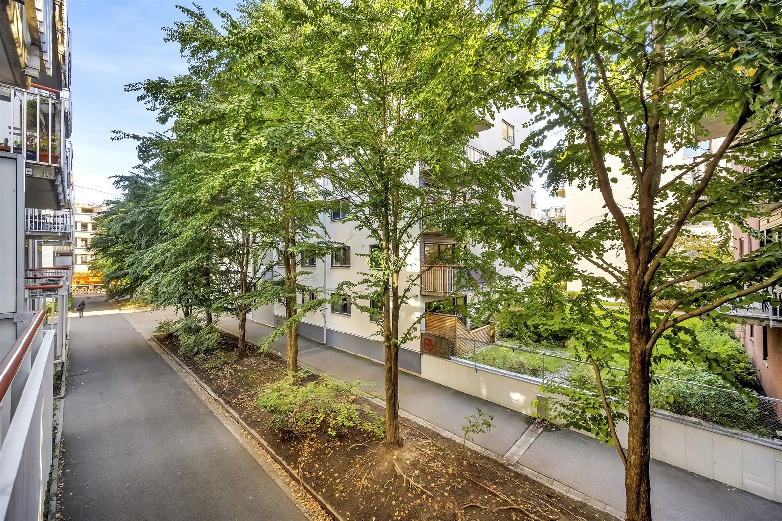 Balkongen har et grønt og fint utsyn mot frodig gatetun. Galleribilde