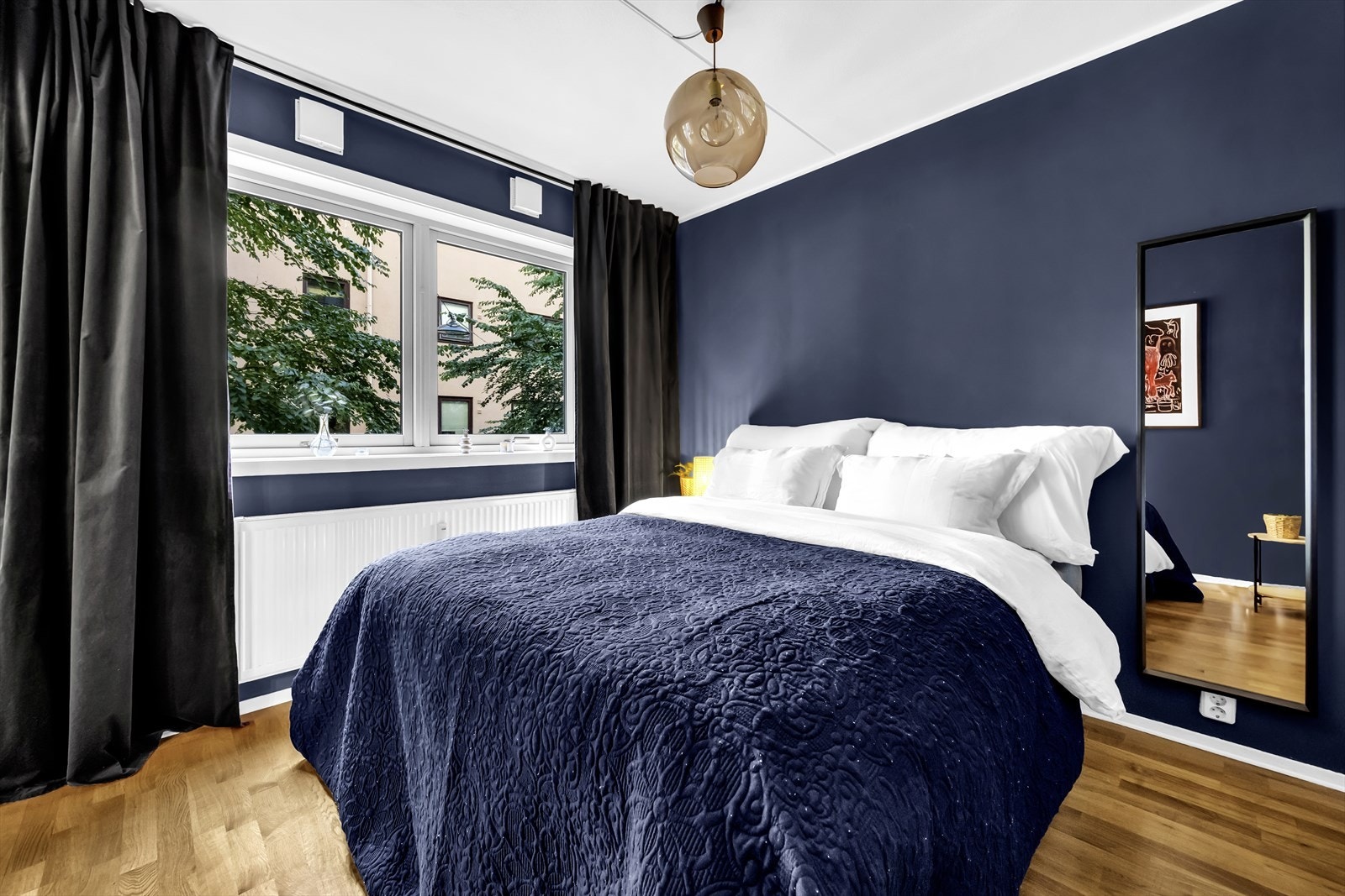 Leiligheten har et lunt og innbydende soverom malt i en behagelig blåtone. Soverommet ble malt i 2022. Galleribilde