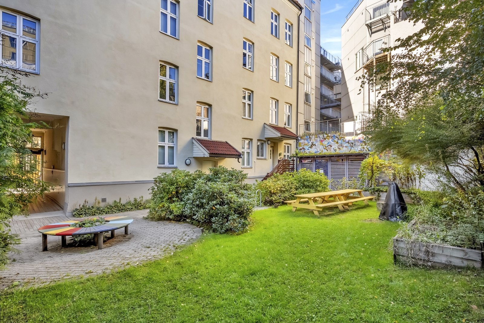 Sameiets fellesareal er pent opparbeidet med brostein, plen og beplantning. Galleribilde