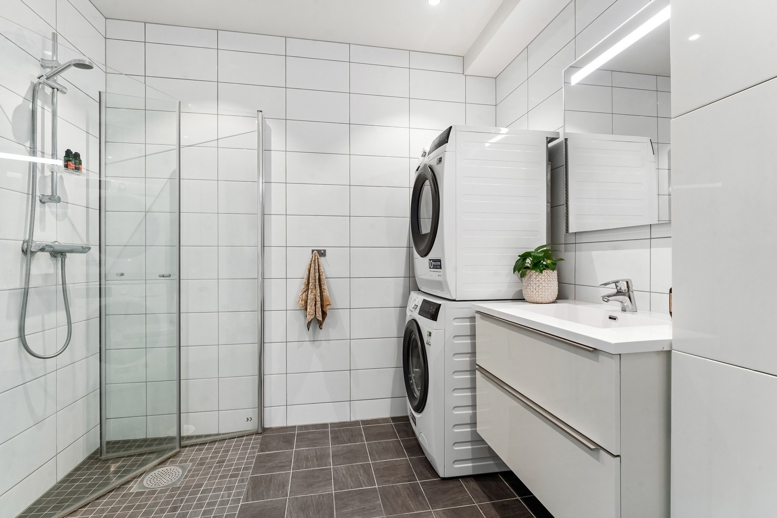 Pent flislagt baderom med gulvvarme fra 2016. Opplegg for vaskemaskin og tørketrommel. Galleribilde