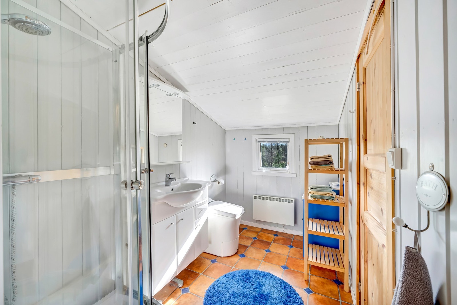 Bad med forbrenningstoalett, servantskap og dusjkabinett. Galleribilde