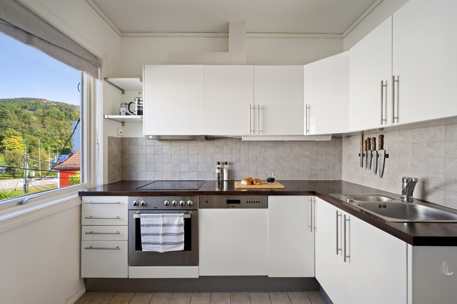 Flott kjøkken med lyse fronter og praktisk innredning med masse skap - og benkeplass. Hvitevarer medfølger i handelen. Galleribilde