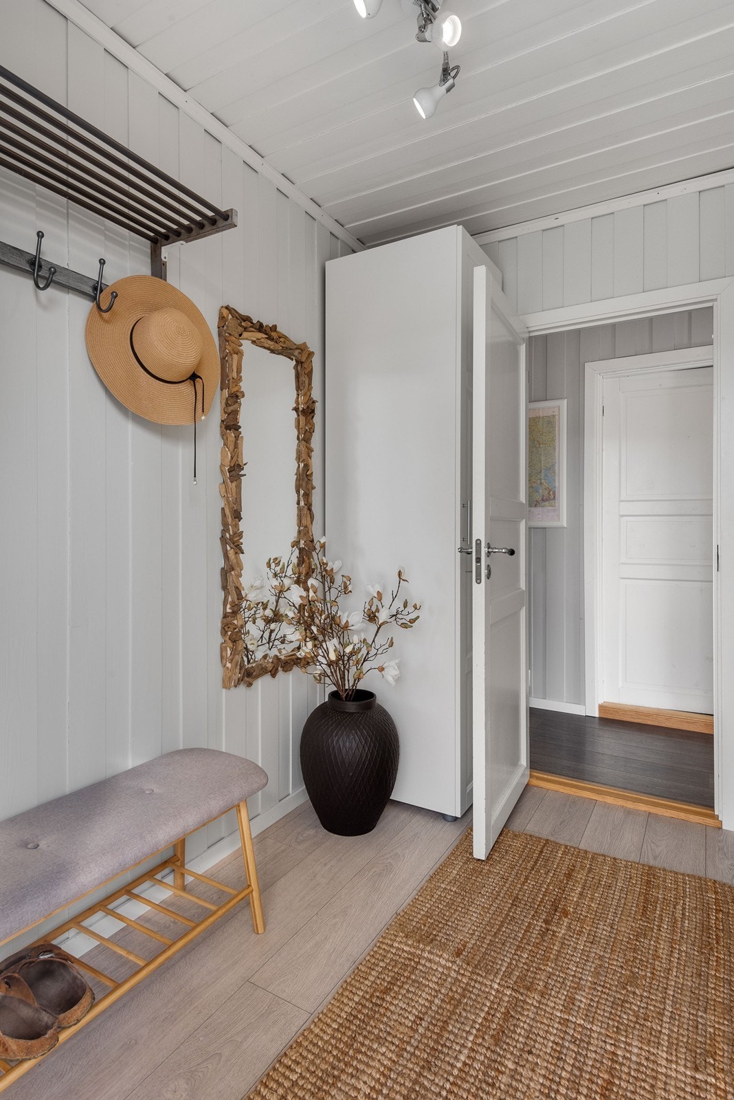 Vel inne er en lys entré med plass for oppheng av yttertøy, hattehylle og flere garderobeskap. Galleribilde