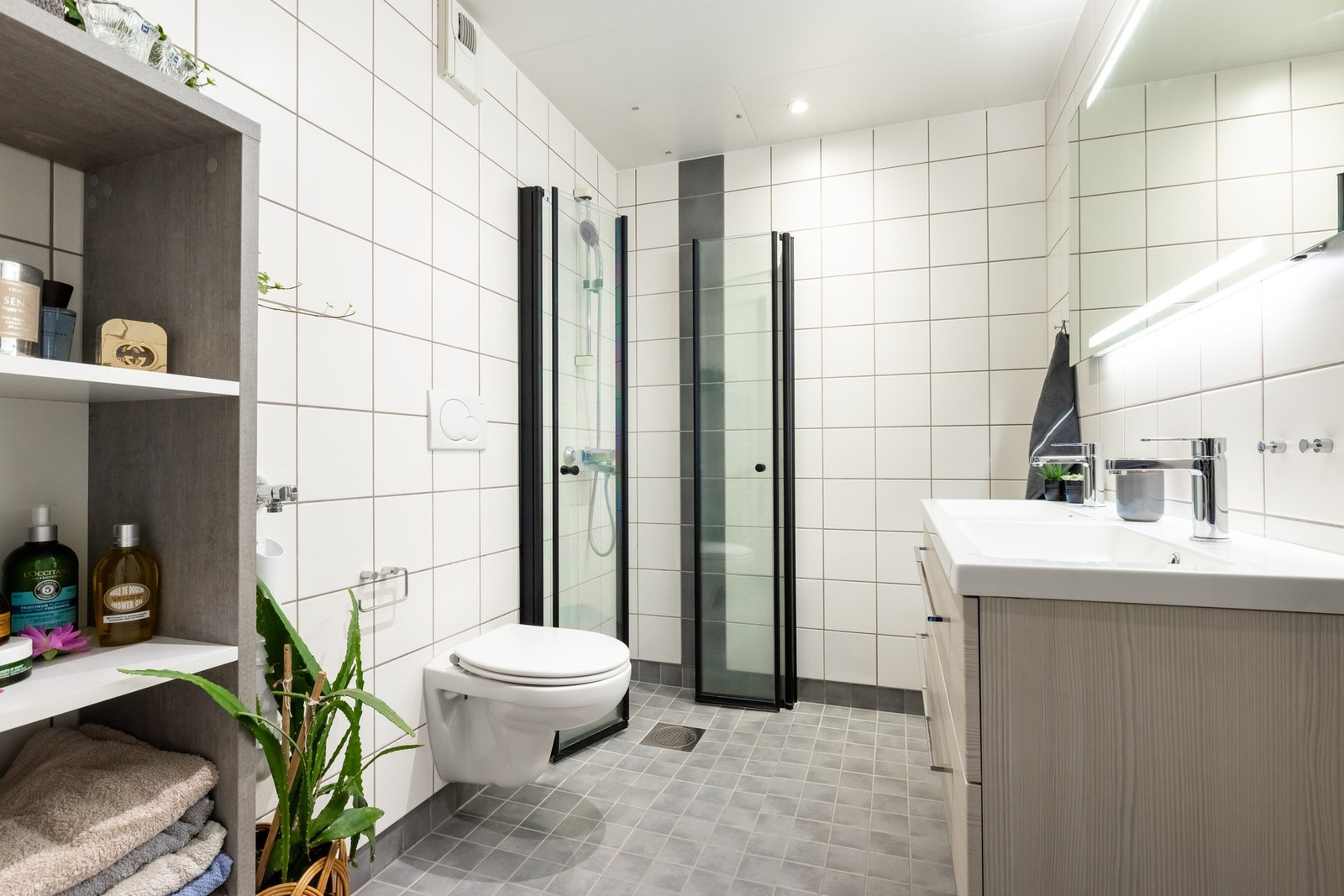 Badet er tidløst innredet og har gulvvarme, romslig dusjhjørne og dobbel vask Galleribilde